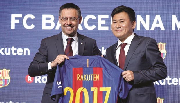 FC Barcelonau2019s President Josep Maria Bartomeu (L) and Rakutenu2019s President and CEO Hiroshi Mikitani pose with a jersey after signing a contract as main sponsor in Barcelona yesterday.