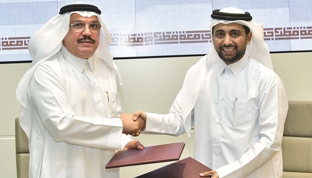 QU president Dr Hassan al-Derham and Goic secretary-general Abdulaziz bin Hamad al-Ageel shake hands after signing the agreement.