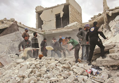 Rescuers and civilians inspect a destroyed building in the Syrian village of Kfar Jales, on the outskirts of Idlib, following air strikes by Syrian and Russian warplanes yesterday. Syrian and Russian warplanes bombed rebel-held areas in Aleppo and Idlib province overnight, a day after Moscow announced a fresh offensive against opponents of its Damascus ally.