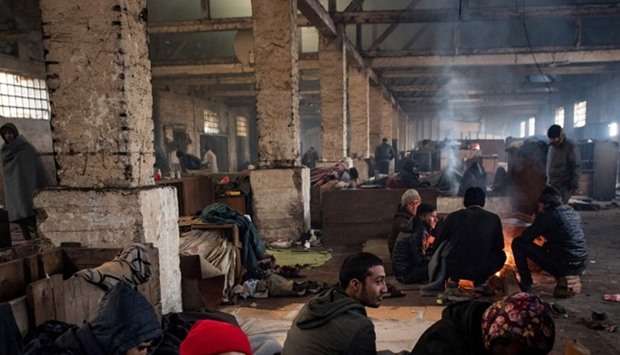 Migrants rest in a makeshift shelter in an abandoned warehouse