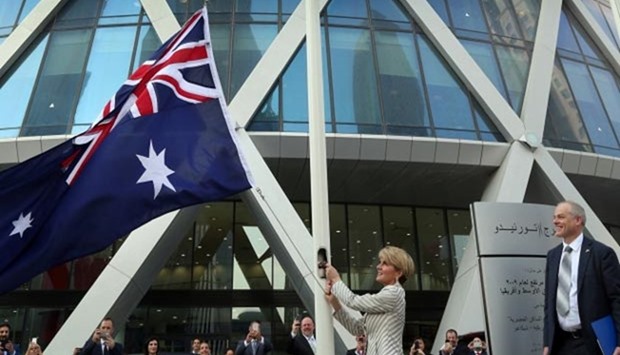 Foreign Minister Julie Bishop unfurls Australia's national flag outside the Tornado Tower as ambassador Axel Wabenhorst looks on. Picture: Jayan Orma