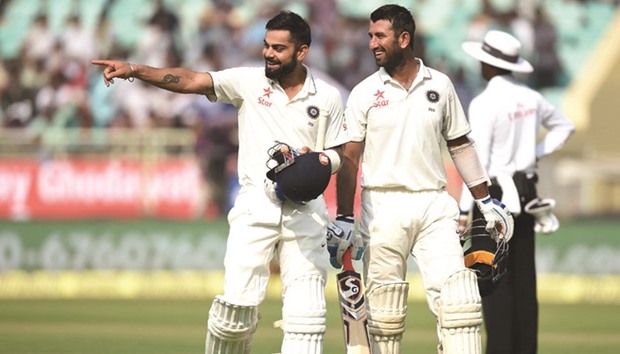 Indiau2019s captain Virat Kohli (left) and Cheteshwar Pujara share a joke as they walk back to the pavilion for tea break during the first day of the second Test in Vishakhapatnam yesterday. (AFP)