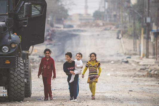 Children emerge from their houses during a lull in the fighting in the Aden neighbourhood of Mosul.