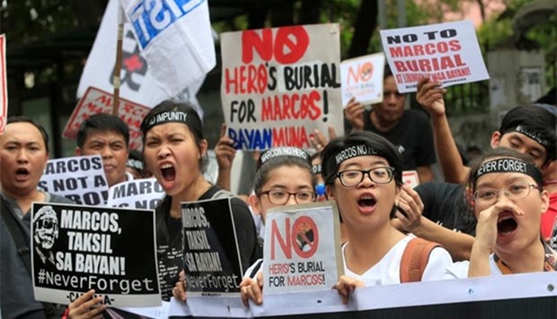 Protesters shout anti-Marcos slogans denouncing the burial of former Philippine dictator Ferdinand Marcos at the Libingan ng mga Bayani (heroes' cemetery), along a main street in Taft avenue, metro Manila on Friday.