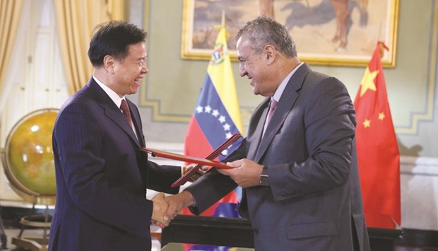 PetroChina chairman Wang Yilin (left) and Venezuelau2019s Oil Minister and president of the Venezuelan state oil company PDVSA Eulogio del Pino shake hands after signing an agreement between the two companies in Caracas on Thursday.
