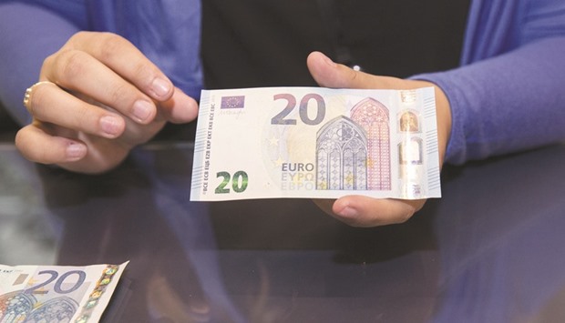 A man shows a new u20ac20 note in Paris. The euro slumped to $1.0569 yesterday, the lowest level since early December last year.