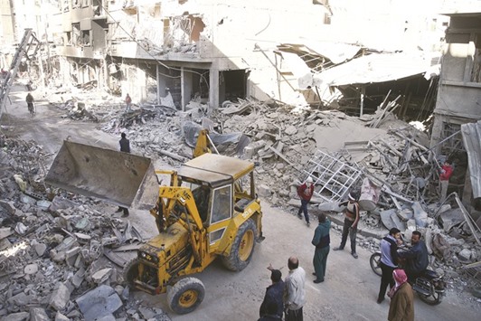 People inspect the damage at a site hit by air strikes in the rebel-held Douma neighbourhood of Damascus yesterday