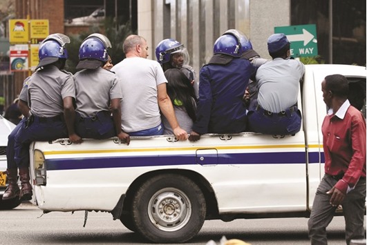 Activists are transported in a police truck after they were detained ahead of a protest in Harare against government plans to introduce a new currency.