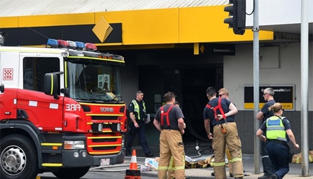 Emergency service workers are seen at a branch of the Commonwealth Bank after a fire injured customers in Melbourne on Friday.