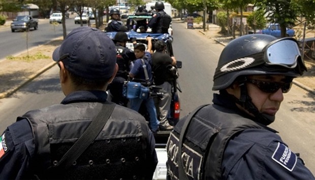 Members of the Mexican Federal Police patrol the area