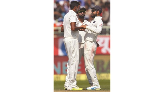Indiau2019s off-spinner Ravichandran Ashwin (left) celebrates with Virat Kohli after the dismissal of Englandu2019s Ben Stokes during the Second Test at the ACA-VDCA Cricket Stadium in Visakhapatnam, India, yesterday. (Reuters)