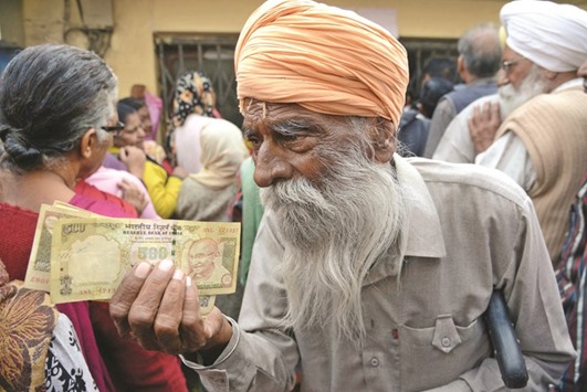 Senior citizens gather outside a bank as they wait to deposit and exchange Rs500 and Rs1,000 notes in Amritsar yesterday.