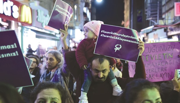 A man with a baby on his shoulders takes part in a protest in the Kadikoy neighbourhood of Istanbul yesterday against a proposed law that would overturn menu2019s convictions for child sex assault if they married their victim.