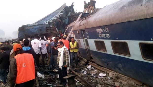 Indian rescue workers search for survivors in the wreckage of a train that derailed near Pukhrayan in Kanpur district on Sunday.