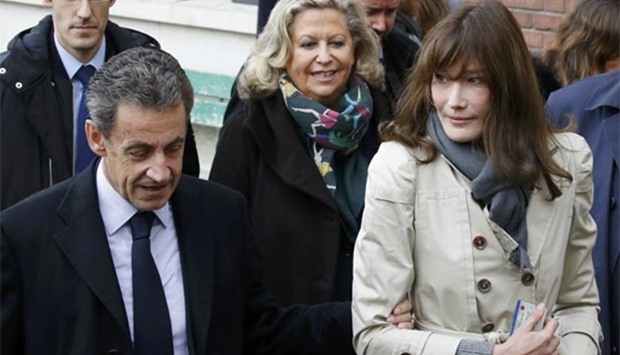 Nicolas Sarkozy and his wife Carla Bruni-Sarkozy leave after they voted in the first round of the French center-right presidential primary election in Paris on Sunday.