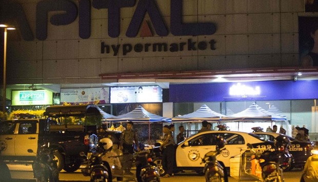 Myanmar police personnel stand guard at a supermarket where three bombs exploded in Yangon