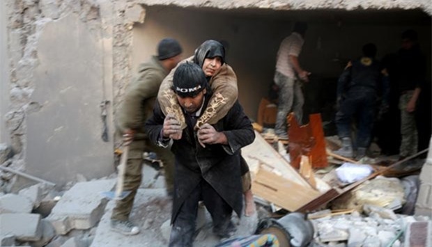 A Syrian rescuer carries a woman who was rescued from the rubble of a building following reported airstrikes on Aleppo's rebel-held district of al-Hamra on Sunday.