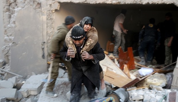 A Syrian rescuer carries a woman who was rescued from the rubble of a building ffollowing reported airstrikes on Aleppo's rebel-held district of al-Hamra
