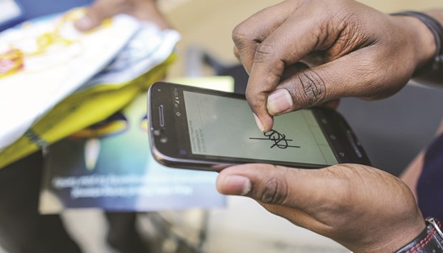A customer signs an e-signature on a smartphone on receiving a package from Ekart Logistics Service in Bengaluru. India overtook the US this year to become the worldu2019s second-largest smartphone market by users and is projected to generate a billion smartphone sales in the next five years.