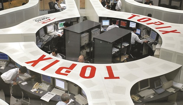 Traders work at the Tokyo Stock Exchange. The Topix index joined the Nikkei 225 in a bull market yesterday, adding 1% to 1,442.93 at the close in Tokyo. The broader stock gauge is up 21% from its low in February.