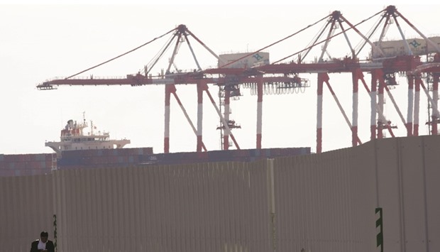 A man is seen in front of cranes at an industrial port in Tokyo. Japanu2019s imports in October fell 16.5% versus the median estimate of a 16.3% fall.