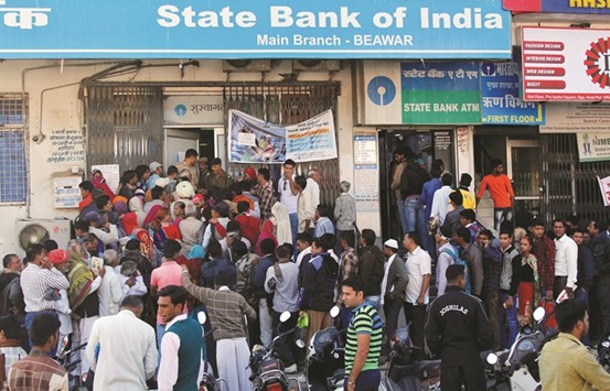 People crowd the entrance of the State Bank of India branch to deposit or exchange their old high denomination banknotes in Beawar city in Rajasthan yesterday.