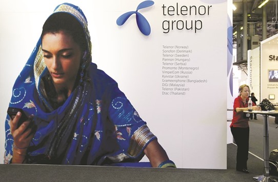 A visitor rests under a Telenor signboard at the GSMA Mobile World Conference in Barcelona. Myanmar accounted for 5.3% of the Norwegian telecoms companyu2019s revenue in the third quarter and was its fastest growing market.