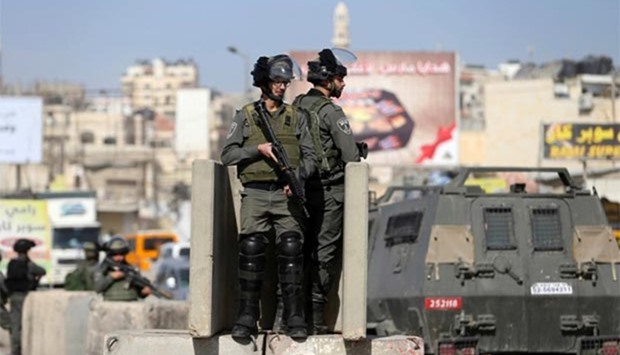 Israeli border policemen stand guard near the scene where a Palestinian was shot and killed by an Israeli security guard after the Palestinian tried to stab him, at Qalandiya checkpoint near the West Bank city of Ramallah on Tuesday.
