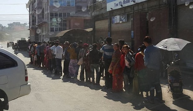A long queue of Myanmar residents wait at the border immigration crossing, to cross into China
