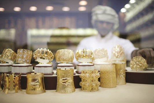 An employee arranges jewellery at a window display in a shop at the Gold Souq in Dubai.   According to the World Gold Council, the new standard will also serve as an internationally  recognised consensus on regular gold savings plans, gold certificates and mining equities.