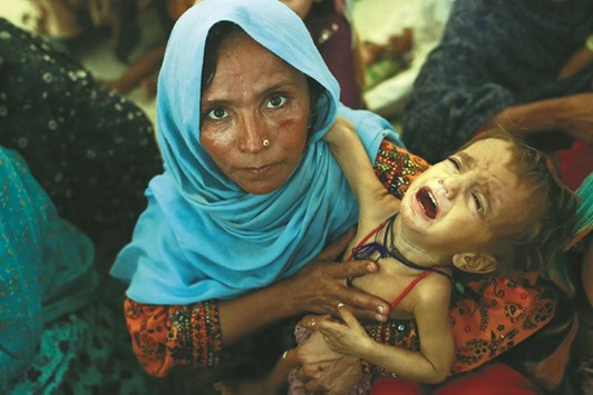 Mah Pari carries her son Gul Mir as she waits for her turn at the mobile feeding centre for Mu00e9decins Sans Frontiu00e8res (MSF) in Dera Murad Jamali.