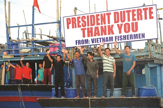 Vietnamese fishermen wave as they prepare to depart during a send-off ceremony led by Philippine President Rodrigo Duterte (not pictured) at the wharf in Sual town, Pangasinan province, north of Manila yesterday.