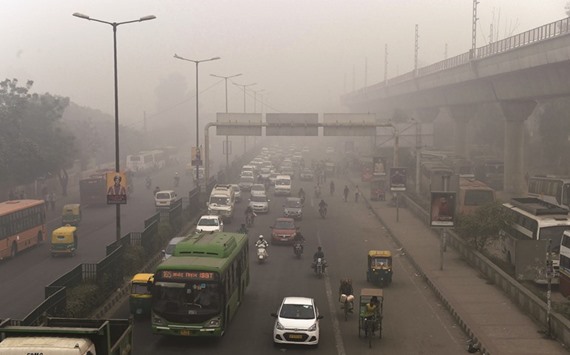 Motorists drive on a major road as smog covers New Delhiu2019s skyline yesterday.