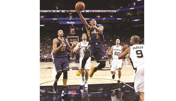 George Hill (centre) of the Utah Jazz drives to the basket during game against the San Antonio Spurs at AT&T Center in San Antonio, Texas, on Tuesday. (AFP)