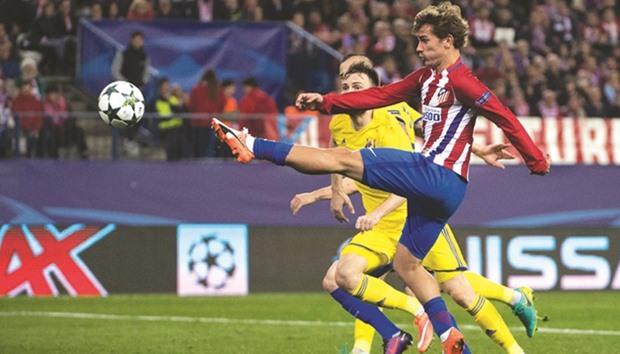 Atletico Madridu2019s French forward Antoine Griezmann (R) scores during the UEFA Champions League Group D match against FC Rostov at the Vicente Calderon stadium.