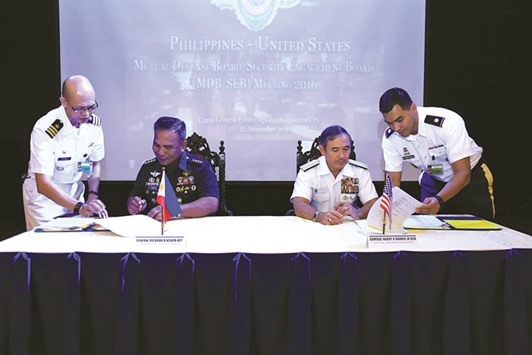 This handout photo taken yesterday and released by Armed Forces of the Philippines-Public Affairs Office (AFP-PAO) shows Philippine military chief General Ricardo Visaya (left) and US Pacific Command chief Admiral Harry Harris signing the activity list for US and Philippine military, during the Mutual Defence Board (MDB) meeting at the military headquarters in Manila.