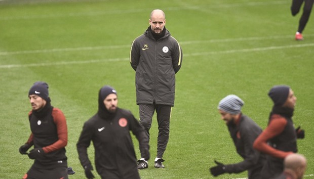 Manchester Cityu2019s Spanish football coach Pep Guardiola (C) attends a training session at the City Football Academy in Manchester, northern England, yesterday.