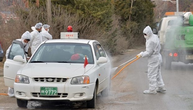 South Korean health officials disinfect a vehicle to prevent spread of bird flu in Pocheon on Wednesday.