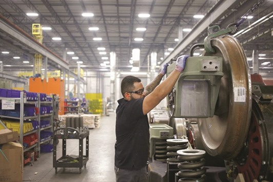 An employee helps install a traction motor onto the truck of an Evolution Series Tier 4 diesel locomotive at the GE Manufacturing Solutions facility in Fort Worth, Texas. The US Commerce Department said non-defence capital goods orders excluding aircraft, a closely watched proxy for business spending plans, rose 0.4% after declining 1.4% in September.
