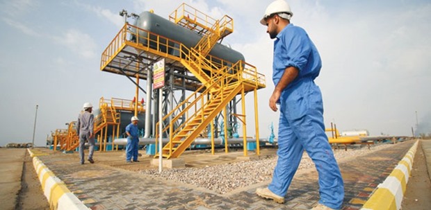 Iraqi labourers work at an oil refinery in Nasiriyah. Iraq is willing to cut its crude oil output as part of Opecu2019s plan to reduce global supply and boost crude prices, Prime Minister Haider al-Abadi told reporters yesterday in Baghdad.