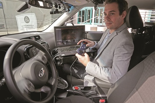 DEMO: Josh Hartung, CEO and co-founder of PolySync Technologies, demonstrates the Open Source Car Control Project using a simple game controller to operate a 2014 KIA Soul in Los Angeles last week. The OSCC project is a hardware kit that allows engineers to develop self-driving cars using existing technologies.