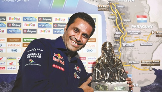 Qatari driver Nasser al-Attiyah poses with a trophy during a press conference in Paris yesterday to present the 2017 Dakar Rally.