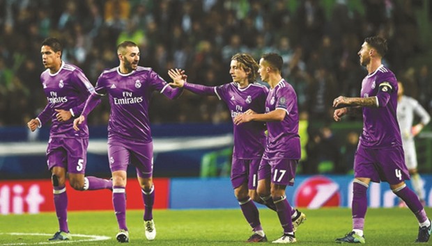 Real Madridu2019s French forward Karim Benzema (second from left) celebrates with teammates after scoring the winning goal in his sideu2019s 2-1 win over Sporting Lisbon in Lisbon on Tuesday night. (AFP)