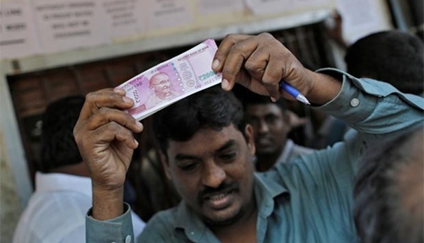A man holds a 2000 rupees note as he gets out of a bank in Mumbai on Thursday.