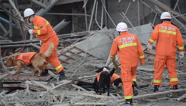 Rescue workers search at the site where a power plant's cooling tower under construction collapsed in Fengcheng, Jiangxi province, on Thursday.