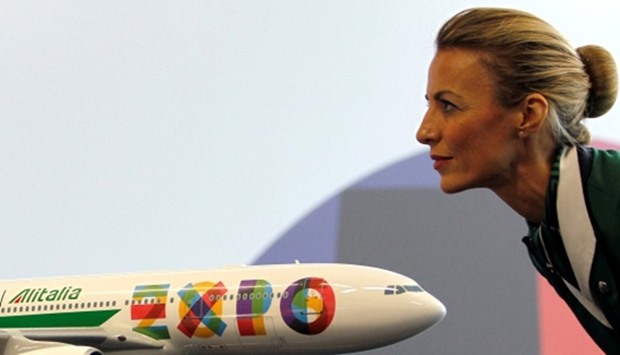 An Alitalia hostess looks at a model of Airbus at Malpensa Airport near Milan, Italy