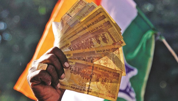 A man displays Rs500 notes during a rally organised by Indiau2019s main opposition Congress party against the governmentu2019s decision to withdraw Rs500 and 1,000 banknotes from circulation, in Ajmer, India, yesterday.