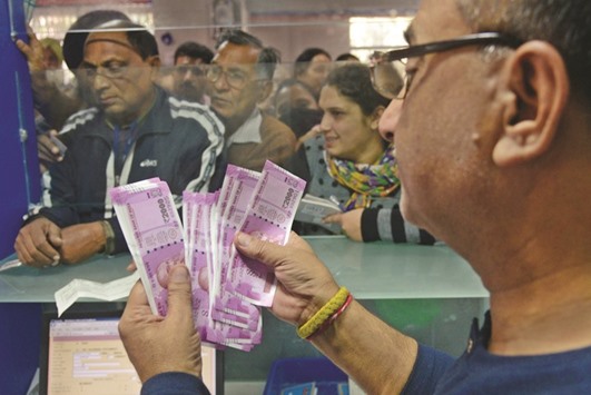 An Indian bank teller counts out notes as senior citizens wait to withdraw money at a bank in Amritsar on Saturday. The rupee has fallen around 3% this month, its biggest fall against the dollar since August 2015, though it has fared better than many other emerging market currencies since Donald Trumpu2019s shock win in the US presidential election.