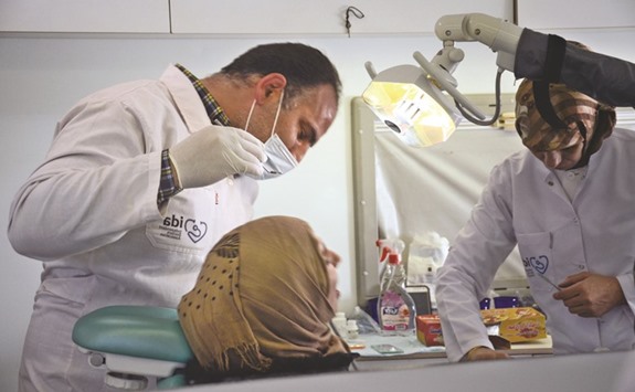 Muhanned Qabtur operates on a patient inside his mobile dental clinic at the Rayan camp for the displaced in the northern province of Aleppo.