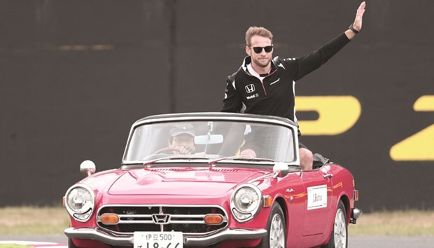 This file photo taken on October 9, 2016 shows McLaren Hondau2019s British driver Jenson Button waving as he rides in a classic Honda convertible during the driversu2019 parade before the start of the Formula One Japanese Grand Prix in Suzuka. (AFP)